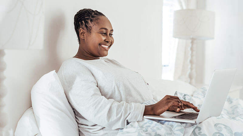 kc bariatric patient reclines in bed and smiles while filling out fmla paperwork