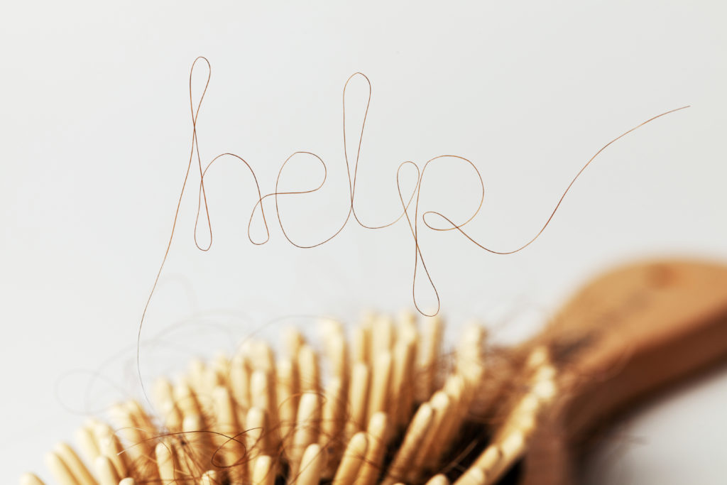 hairbrush with hair spelling out "help"