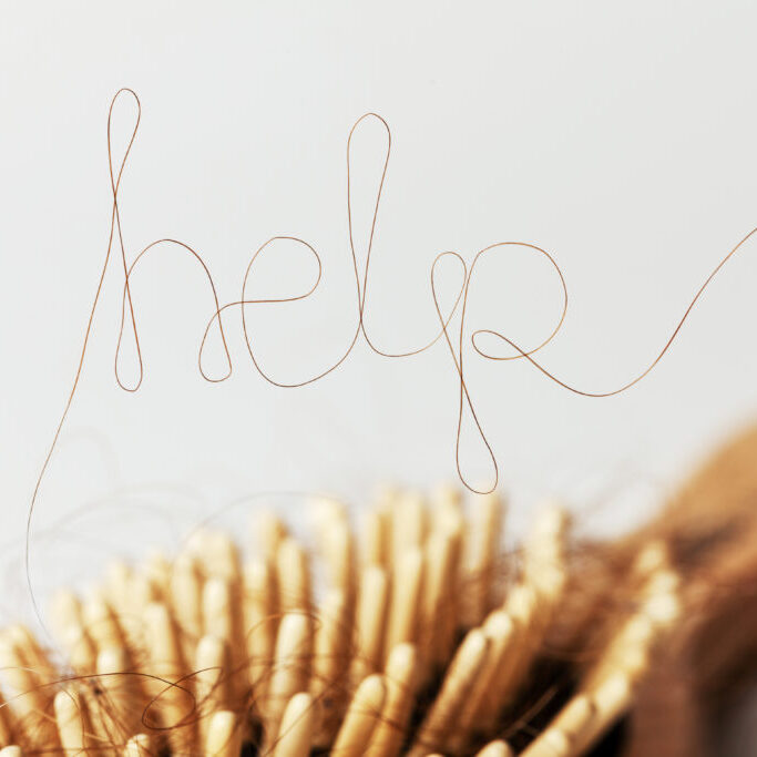 hairbrush with hair spelling out "help"