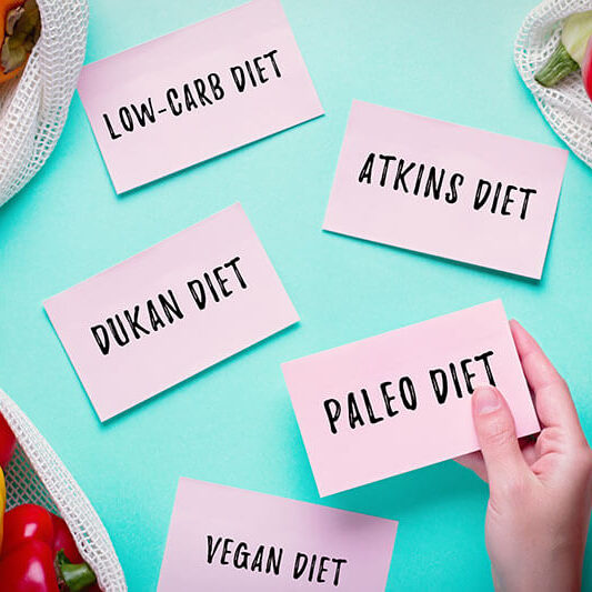 a list of diet fads on pink paper over turquoise background